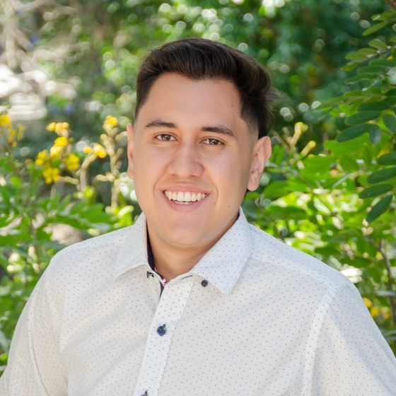Mauricio Carrillo smiling, in a white shirt.